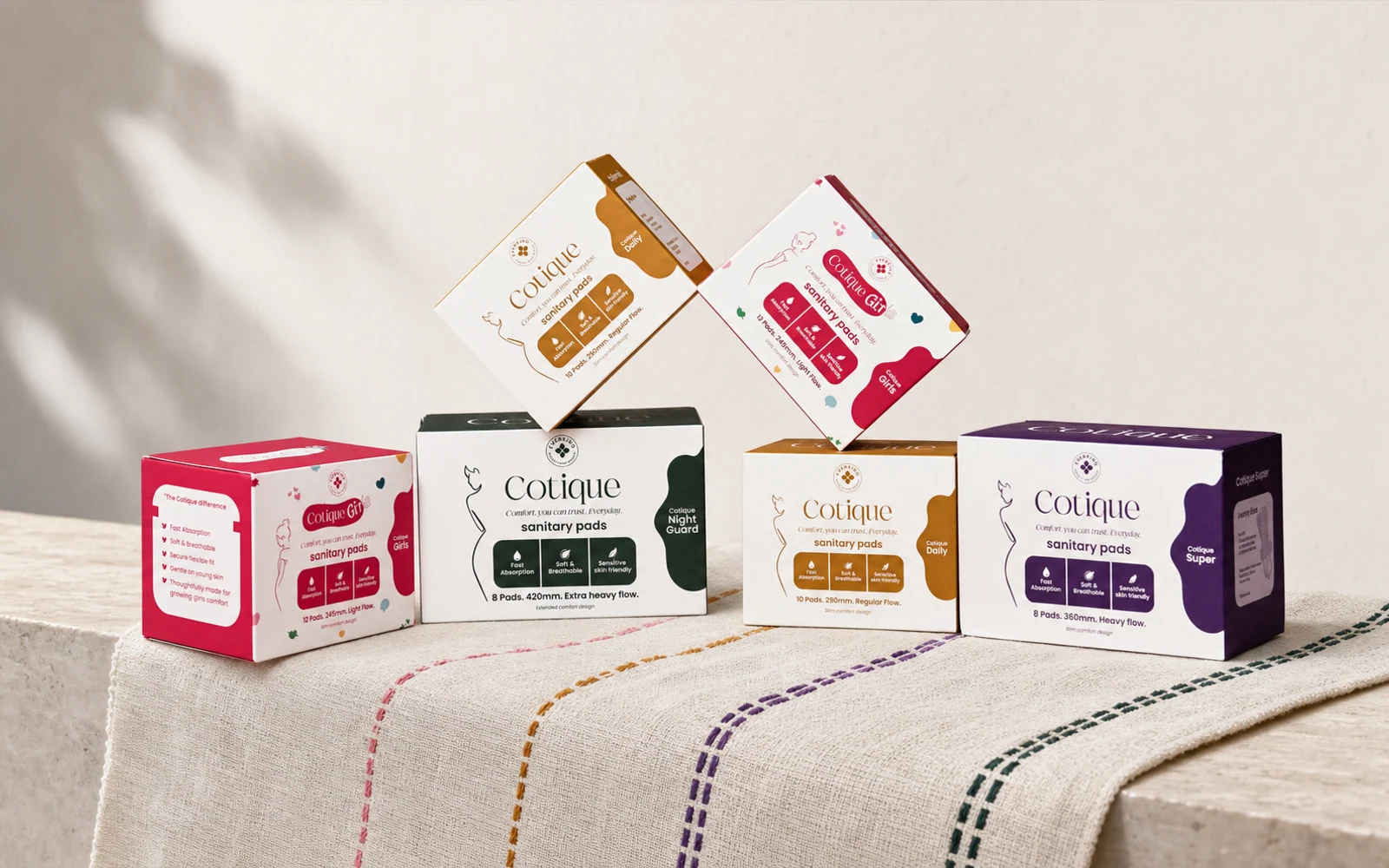 The Cotique range photographed on woven cloth with four colour-coded stitched paths